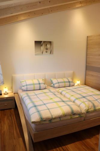 a bedroom with a bed with two pillows at Ferienwohnung Bichelblick in Hopferau