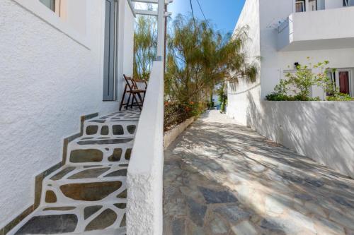 a narrow alley with white walls and a white building at Filoxenia Apartments in Adamas