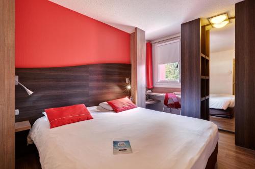 ラ・ロッシュ・シュル・ヨンにあるキリアド ラ ロシュ シュル ヨンの赤い壁のベッドルーム1室(大型ベッド1台付)