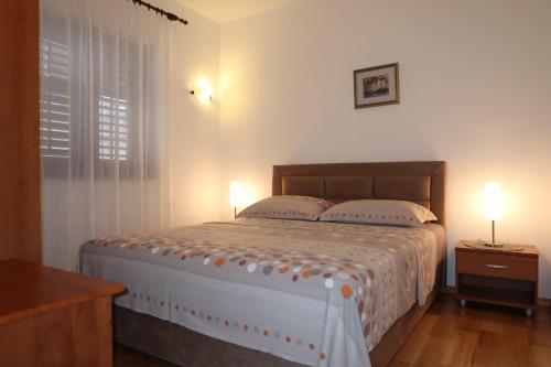 a bedroom with a large bed with two pillows at Apartment Makarska City Center with Sea View VII in Makarska