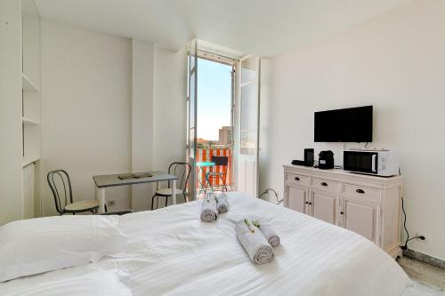 une chambre avec un lit blanc avec des serviettes dessus dans l'établissement IMMOGROOM - Studio - Sea view next to the Palais - CONGRESSBEACHES, à Cannes