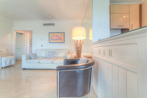 un salon avec un canapé blanc et une table dans l'établissement IMMOGROOM - Sea view - Terrace- Swimming-Pool 1 min from the beach, à Cannes