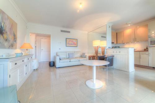 une cuisine et un salon avec une table et un canapé dans l'établissement IMMOGROOM - Sea view - Terrace- Swimming-Pool 1 min from the beach, à Cannes