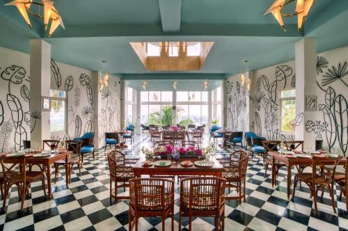 um restaurante com mesas e cadeiras de madeira e um piso em xadrez em Clarks Exotica Island House, Portblair em Port Blair
