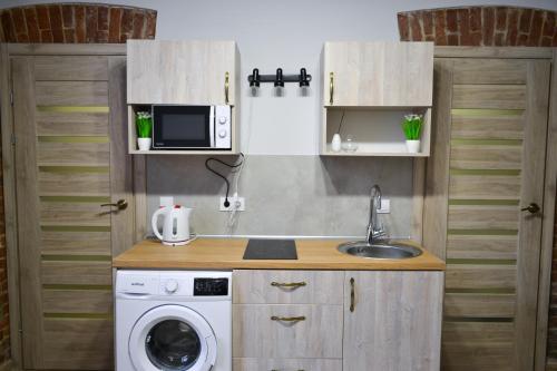 Il comprend une cuisine équipée d'un lave-linge et d'un évier. dans l'établissement Aquamarine apartments Lviv, à Lviv