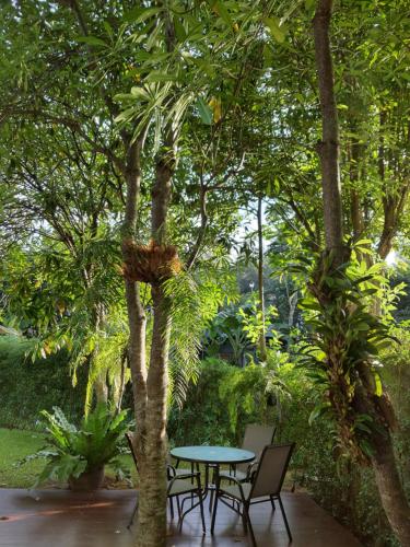 a patio with a table and chairs under a tree at Casa Khaoyai Bed&Breakfast in Mu Si