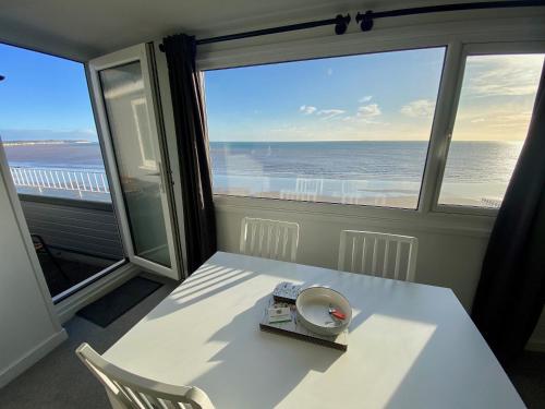 Bridlington Bay Apartments في بريدلينغتون: غرفة مع طاولة بيضاء وإطلالة على المحيط