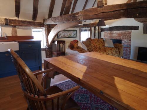 a living room with a wooden table and a couch at The Queen's Head in Hawkedon