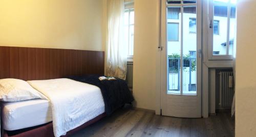 a bedroom with a bed and a sliding glass door at Antica Trattoria in Cles