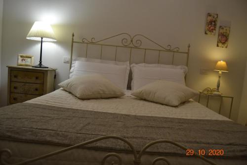a bedroom with a bed with two pillows and a lamp at La Colombara - Fra i colli a 5 minuti dall'autodromo in Imola