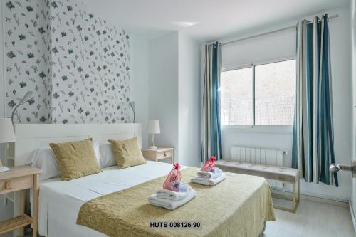 バルセロナにあるAlcam Rogentのベッドルーム1室(ベッド1台に人形2人が座るベッド付)