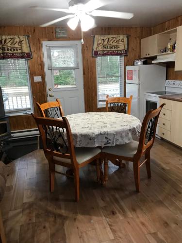 a dining room with a table and four chairs at Aux Pignons Rouges Camping & Chalets in Saint Romain