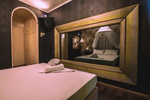um quarto com um espelho e uma cama em Ruby Rooms Kifisia em Atenas