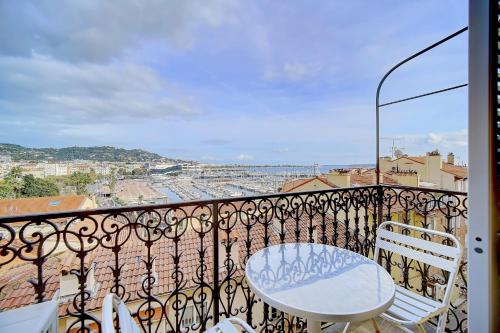 d'un balcon avec une table et des chaises blanches. dans l'établissement IMMOGROOM - SEA View on the Port - Next to the beaches - AC - Wifi, à Cannes