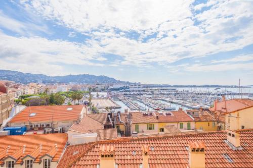 - une vue sur une ville avec des toits et un port dans l'établissement IMMOGROOM - SEA View on the Port - Next to the beaches - AC - Wifi, à Cannes
