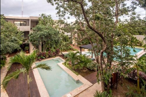 an image of a swimming pool in front of a building at Panacea Condo Tulum in Tulum