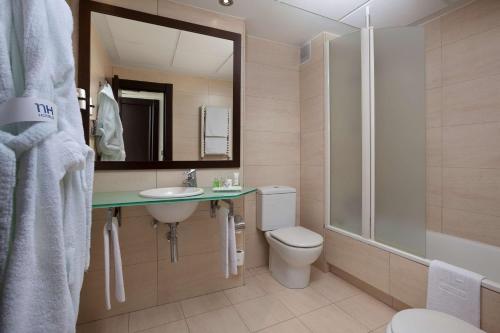 een badkamer met een toilet, een wastafel en een douche bij NH Ciudad de Santander in Santander