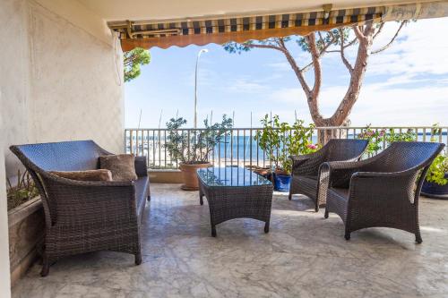 d'une terrasse avec des chaises en osier, une table et un arbre. dans l'établissement IMMOGROOM- Huge Terrace - Panoramic Sea View - 1min from Beach, à Cannes