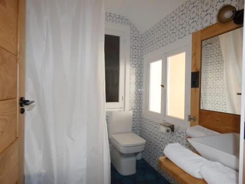 a bathroom with a toilet and a sink and a window at ATICO LA PEÑA in Luarca