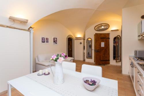 eine Küche und ein Wohnzimmer mit einem Tisch mit Blumen darauf in der Unterkunft Casa Vannucci in Perugia