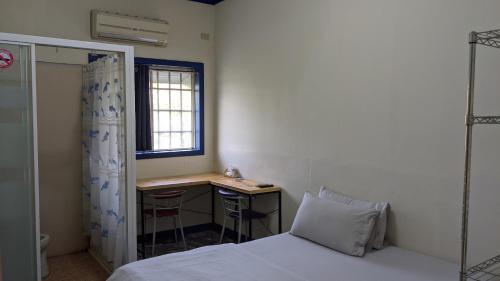 a bedroom with a bed and a desk and a window at 鐵騎休息棧 in Fangliao