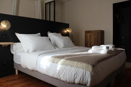 a bedroom with a large bed with white sheets and pillows at Maison Caju - La Rochelle in La Rochelle