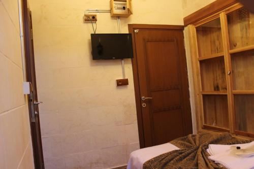 a room with a bed and a tv on the wall at Duran Aga Konagi in Şahinbey
