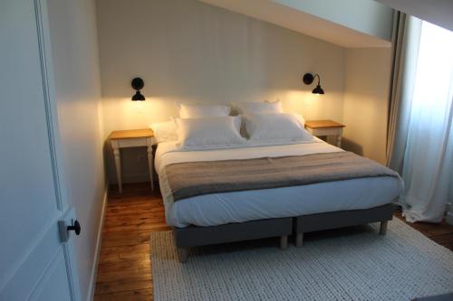 a bedroom with a bed with two tables and two lamps at Maison Caju - La Rochelle in La Rochelle