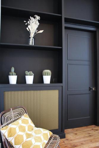 a room with a door and a shelf with potted plants at Maison Caju - La Rochelle in La Rochelle