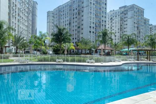 a large blue swimming pool with tall buildings in the background at Minha Praia in Rio de Janeiro