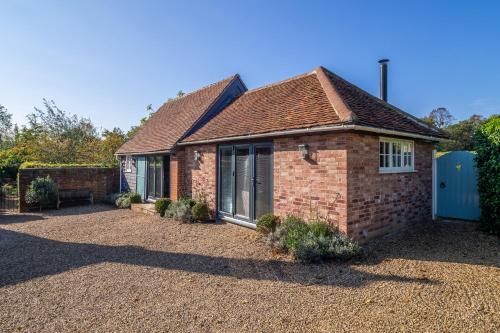 a brick house with a gravel driveway at Romantic cottage in pretty village with great pubs - Stoke Cartlodge in Colchester