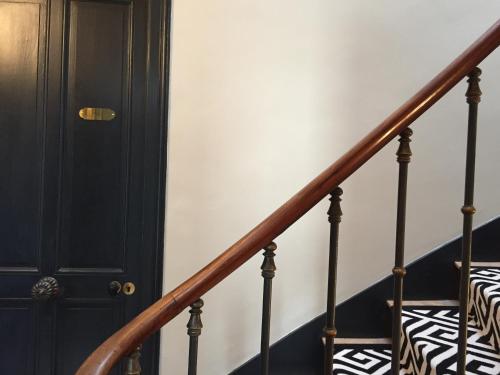 a black door and stairs with a zebra print pillow at Maison Caju - La Rochelle in La Rochelle