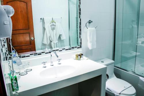 a bathroom with a white sink and a toilet at El Polo Hotel & Suites in Lima