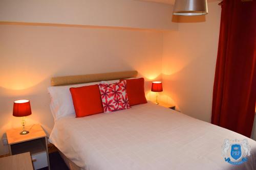 a bedroom with a bed with two lamps on two tables at Two Bedroom Town Centre Apartment in Elgin