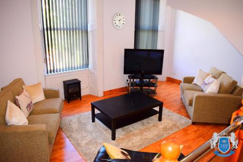 a living room with two couches and a tv at Two Bedroom Town Centre Apartment in Elgin