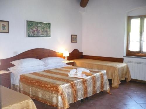 レッジェッロにあるAgriturismo La Ripaのベッド2台と窓が備わるホテルルームです。