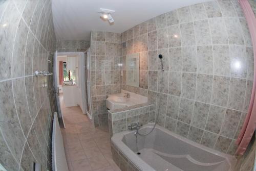 y baño con bañera y lavamanos. en Holiday Home Le Pihon en Gouvy