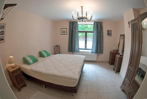 Un dormitorio con una cama grande y una ventana en Holiday Home Le Pihon, en Gouvy