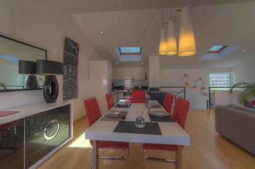 カンヌにあるIMMOGROOM - Beautiful duplex - Sea view - Quiet - AC - Wifi - Garageのキッチン、リビングルーム(テーブル、赤い椅子付)