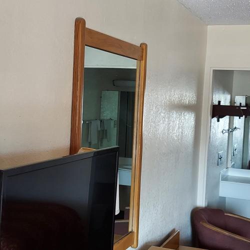 a television sitting in front of a mirror at University Inn & Suites Brownsville in Brownsville