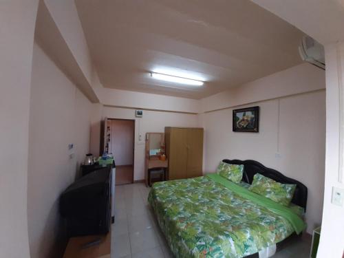 a bedroom with a bed and a chair in it at Vanlisut Hotel Ngamwongwan in Nonthaburi