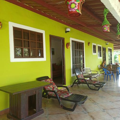 a room with a green wall with chairs and a table at La Casa de Thurys in Pedasí Town