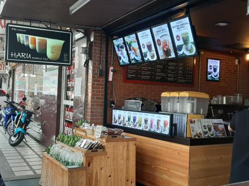 a coffee shop with a menu on the wall at Vanlisut Hotel Ngamwongwan in Nonthaburi