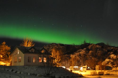 an image of the aurora borealis in the sky over a house at Kabelvåg Feriehus & Camping in Kabelvåg