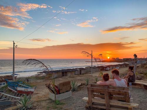 a group of people sitting on a bench watching the sunset at Free Spirit Ecuador, Puerto Engabao in Engabao