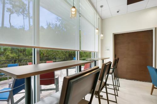 a conference room with tables and chairs and a large window at Holiday Inn Express - Jacksonville South Bartram Prk by IHG in Jacksonville