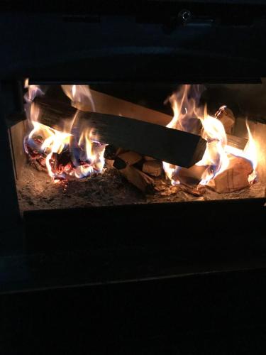 a fire in an oven with a knife in it at Aux Pignons Rouges Camping & Chalets in Saint Romain