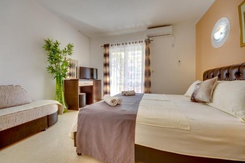 um quarto com uma cama grande e um sofá em Aparthotel Villa Primafila em Ulcinj