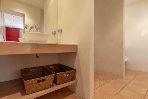 ein Bad mit einem Waschbecken und einem Spiegel in der Unterkunft Bormes les Mimosas in Bormes-les-Mimosas