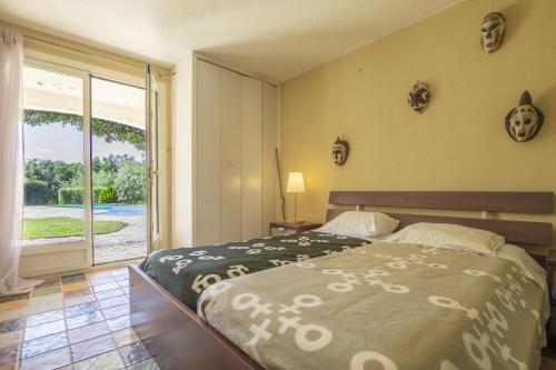 une chambre avec un lit et une porte coulissante en verre dans l'établissement Mouramour, à Grimaud